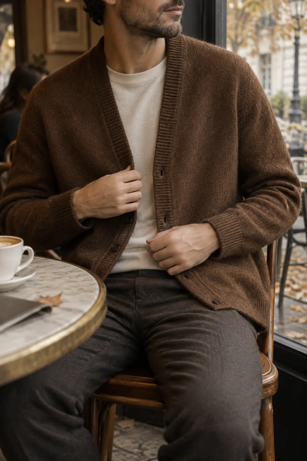 Brown knitted cardigan over a light shirt in a cafe